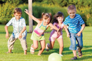 Children playing football in the sun